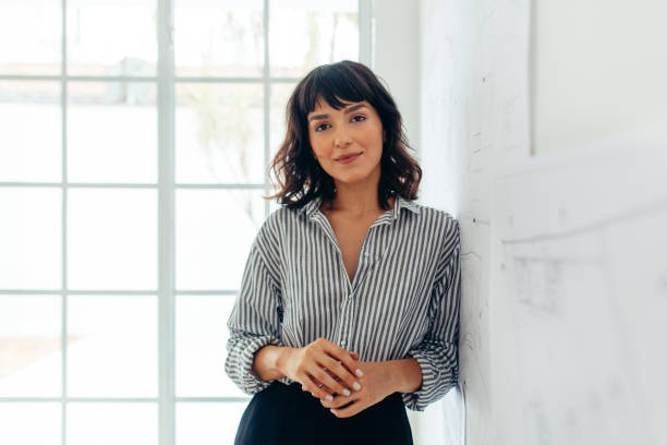 Home 2 Businesswoman standing in office. Portrait of a confident businesswoman